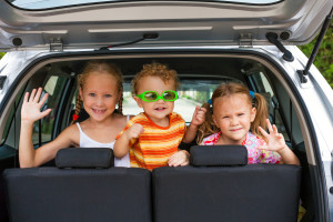 three happy kids in the car